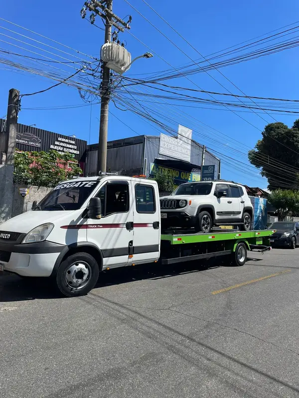 Guincho plataforma transportando um SUV branco