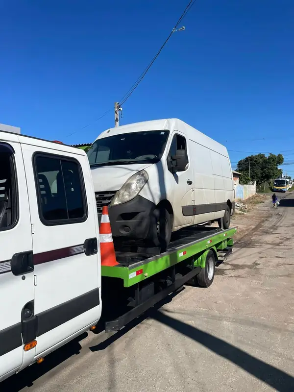 Van branca sendo transportada na plataforma